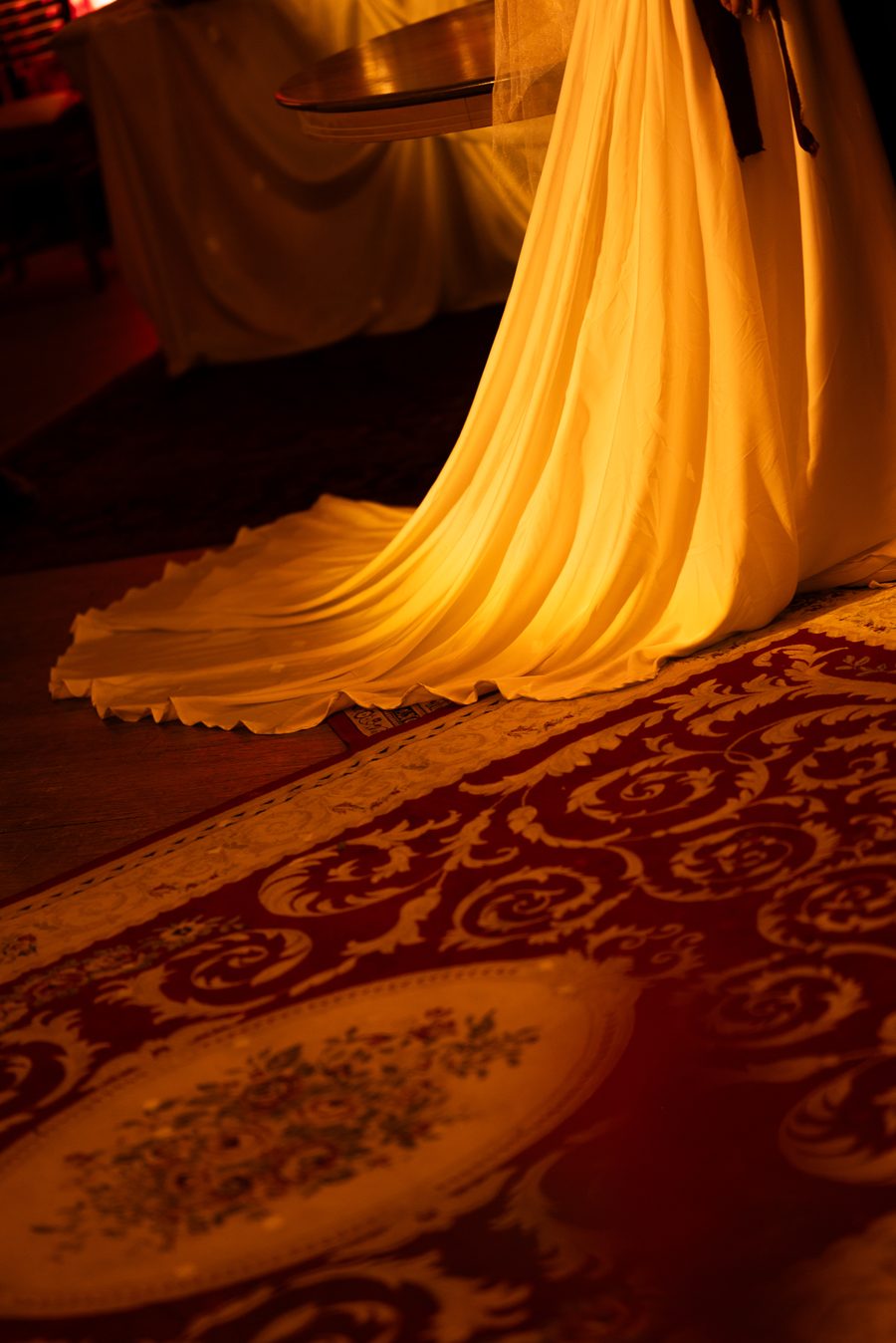 Cauda do vestido de noiva iluminada sobre o tapete