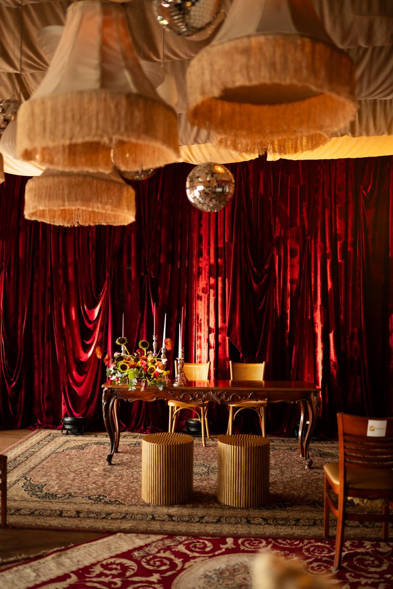 Salão com cortinas de veludo vermelho e mesa de cerimônia